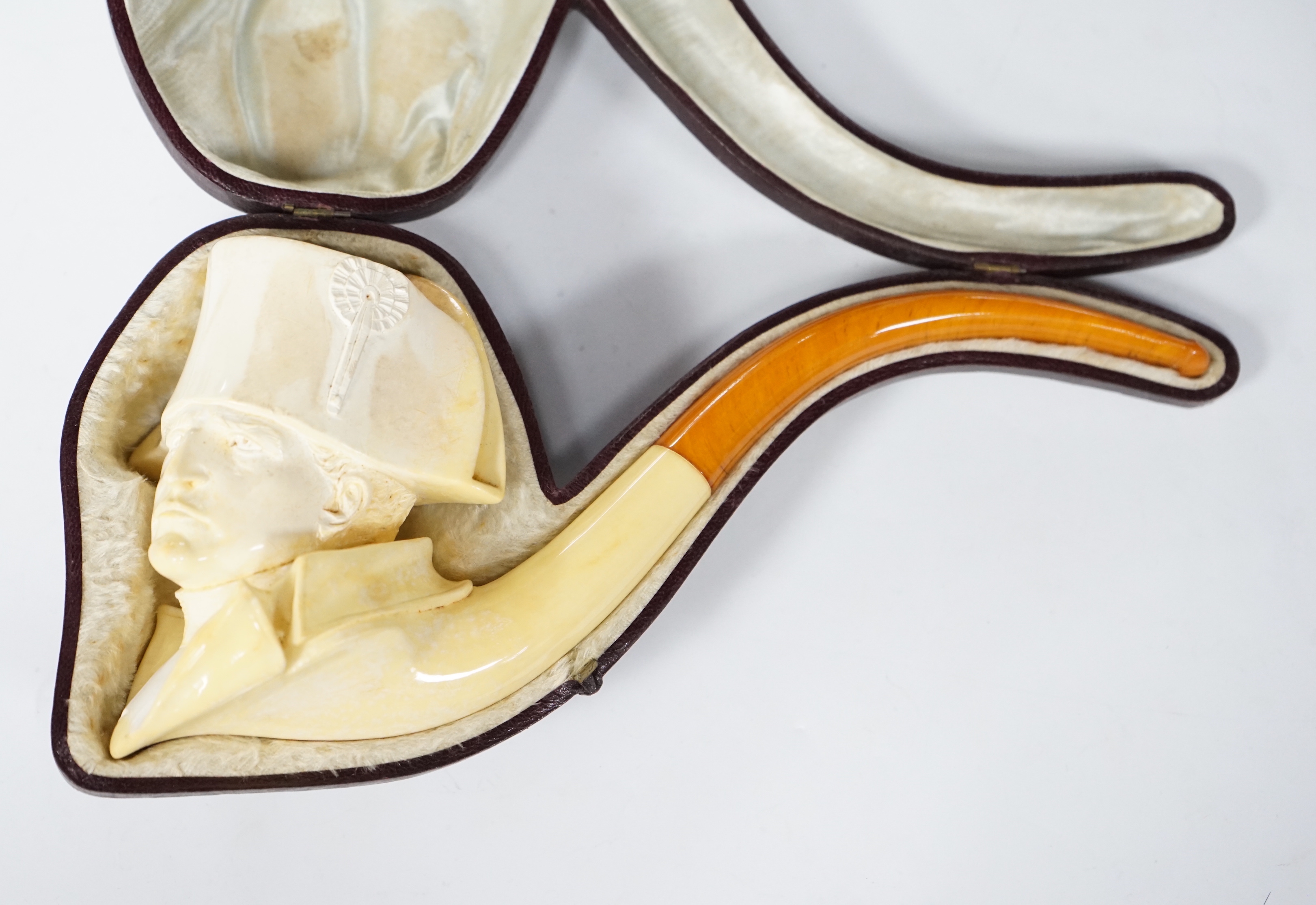 A large cased Meerschaum ‘Napoleon bust’ novelty pipe, early 20th century, with amber mouthpiece, 24cm long